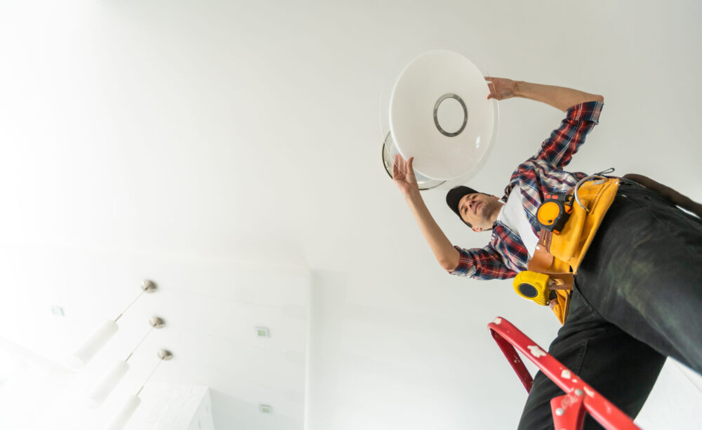 electrician installing led light bulbs in ceiling lamp. High quality photo